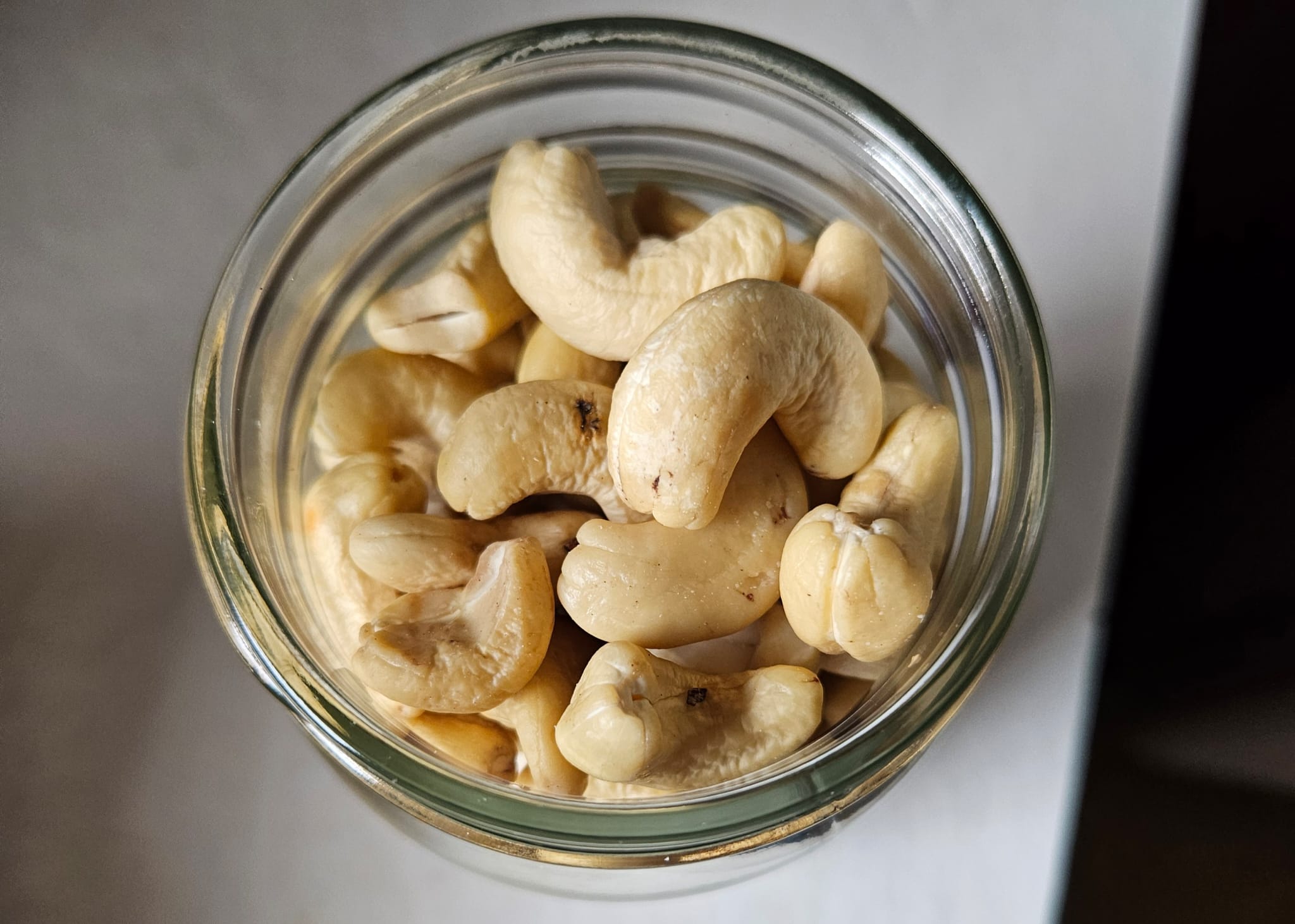 a foto of raw unsalted cashews inside of a glass jar. 